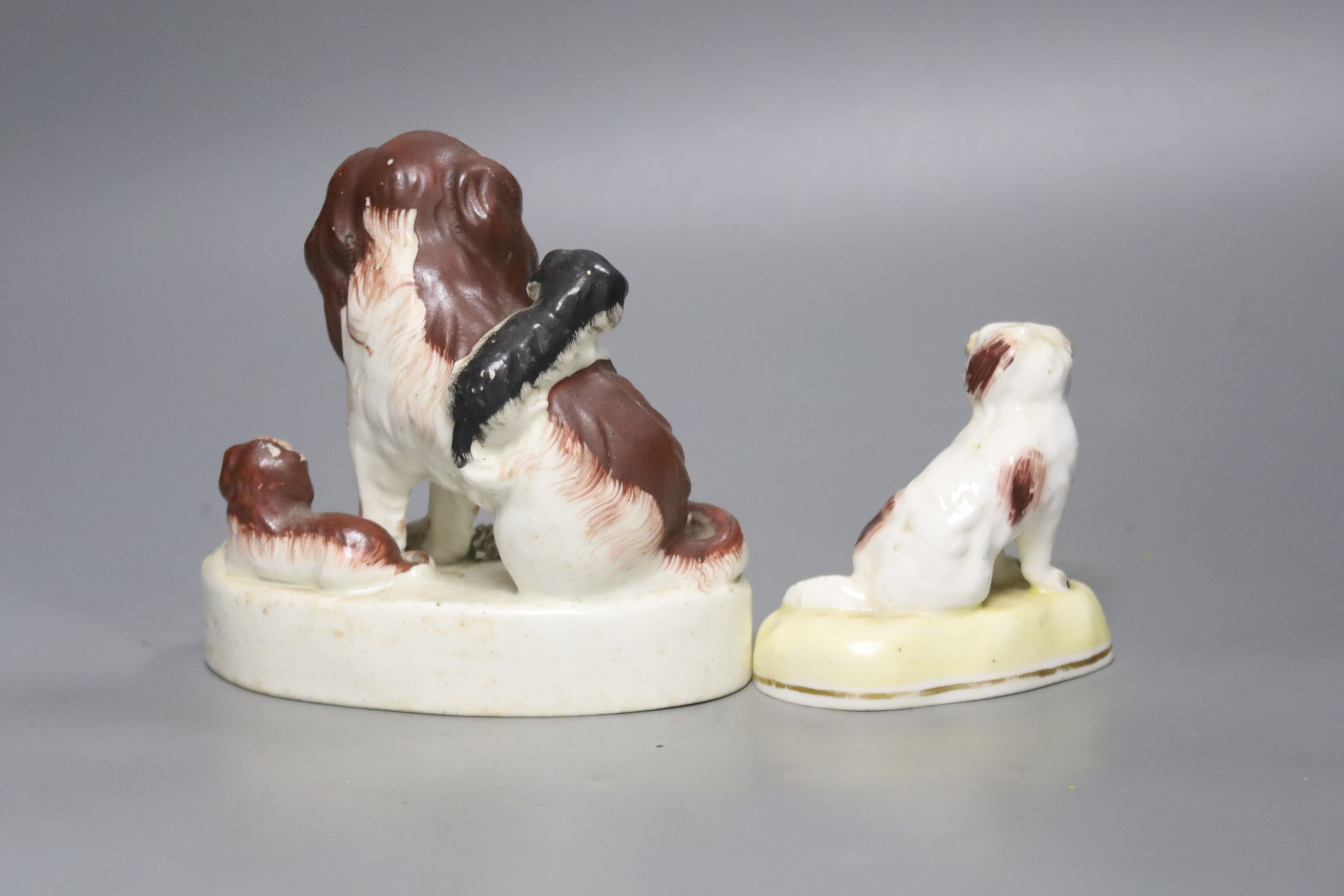 A Victorian Staffordshire spaniels group and a small porcelain dog